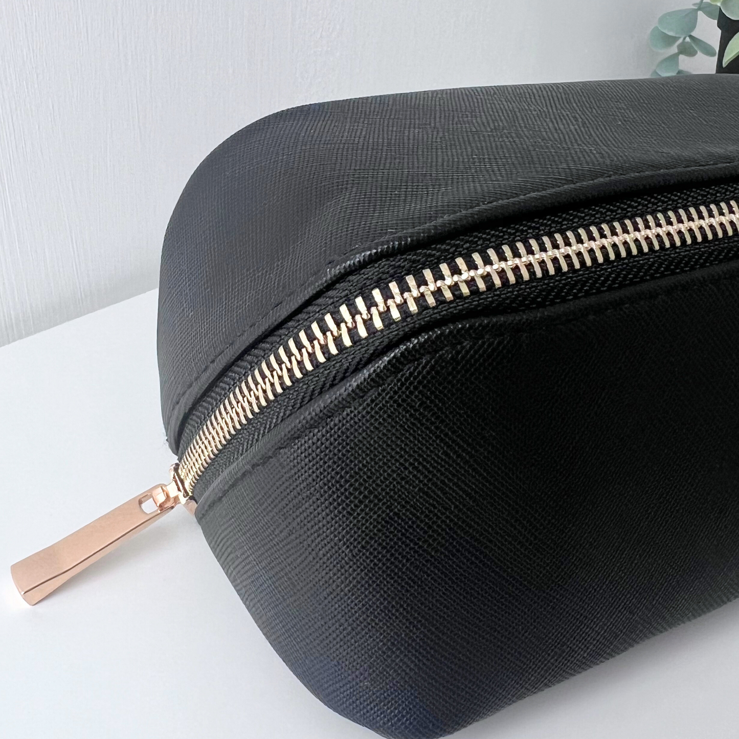 CLOSE UP OF THE ZIP ON BLACK FLAT LAY MINI MAKE UP BAG